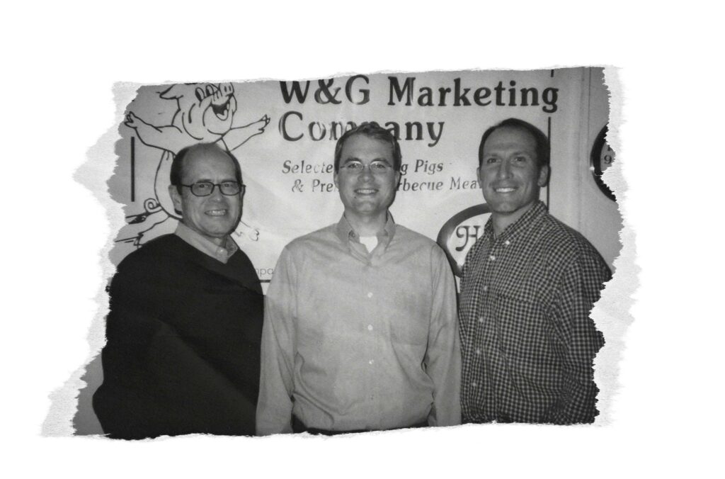 Three men in front of a W&G marketing company sign.